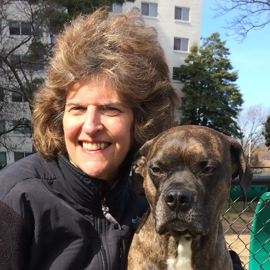 Terri Medwed smiling outdoors with her dog